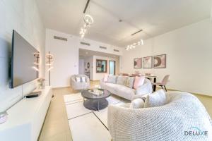 ein Wohnzimmer mit einem Sofa und einem TV in der Unterkunft Impeccable 2BR at Bahar 2 JBR by Deluxe Holiday Homes in Dubai
