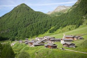 un pueblo en una colina con montañas en el fondo en Traterhof-Spinges, en Rio di Pusteria