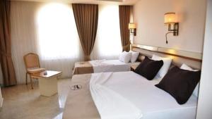 Un pat sau paturi într-o cameră la Akitu Hotel