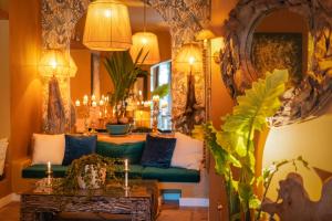 een woonkamer met een groene bank en een spiegel bij La Capria Suite Hotel Alacati in Alacati