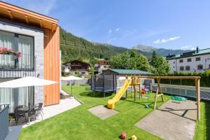 een achtertuin met een glijbaan en een speeltuin bij Alpenleben in Sankt Anton am Arlberg