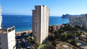 a tall white building next to the ocean at Pintor Rosales 3 dormitorios mirando al mar - Fincas Arena in Benidorm