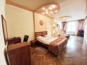 a bedroom with a bed and a dresser at Ratusha Apartments in Lviv