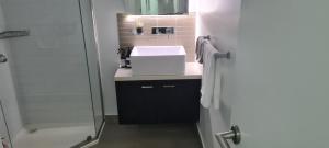 La salle de bains est pourvue d'un lavabo et d'une douche. dans l'établissement MELBOURNE STAR APARTMENT, à Melbourne