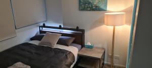 a bedroom with a bed and a table with a lamp at MELBOURNE STAR APARTMENT in Melbourne
