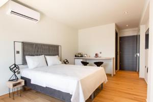 - une chambre avec un grand lit blanc et un bureau dans l'établissement Olumpoy Residences, à Thessalonique