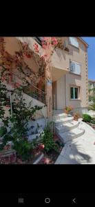 a building with a tree in front of it at Apartmani Tanja in Tivat