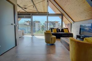 a living room with a couch and a television at HelApart - Loft in Hel