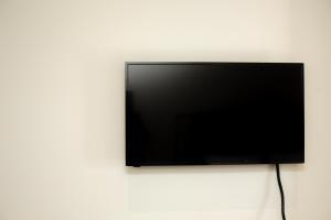 telewizor z płaskim ekranem wiszący na ścianie w obiekcie Olumpoy Residences w Salonikach