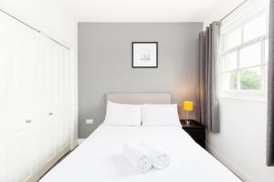 a white bedroom with a white bed and a window at Marvel Apartments Leamington Spa in Leamington Spa