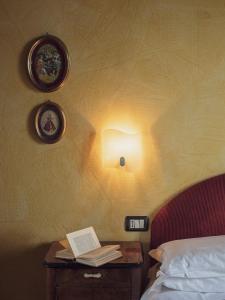 Un dormitorio con una cama y una mesa con un libro en Fattorie di Montechiaro, en Sasso Marconi