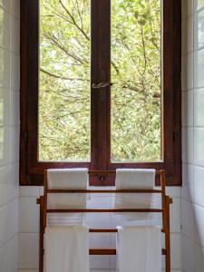 2 sillas y una mesa en una habitación con ventana en Fattorie di Montechiaro en Sasso Marconi