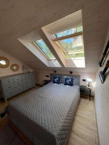a bedroom with a large bed with two windows at Jodłowy Zakątek NEW in Niechorze