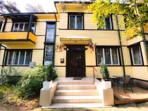 a yellow house with a front door and stairs at Gedimino 1 in Palanga