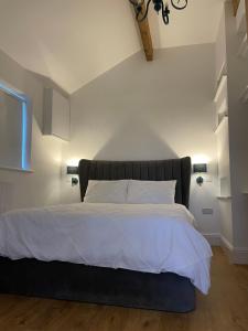 a bedroom with a large bed with white sheets at Brand new purpose built annex :- The Stables in Halifax