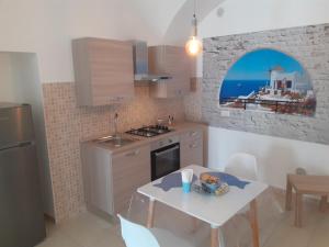 une cuisine avec une table et une petite cuisine avec une table et des chaises dans l'établissement B&By in viaggio, à Putignano