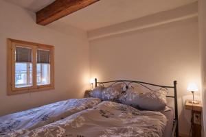 un letto in una camera da letto con due lampade e una finestra di Ferienwohnung Oberlausitzer Hof a Leutersdorf