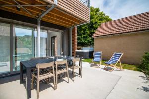 eine Terrasse mit einem schwarzen Tisch und Stühlen in der Unterkunft Bella, Jacuzzi Partagé & Parking avec Borne de Recharge Voiture Electrique in Sarlat-la-Canéda