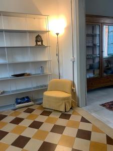 Casa dai Toni Cortesi 2 في بيرغامو: غرفة بها كرسي ومصباح وأرضية مربعة