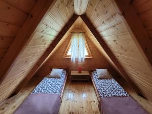 a attic room with two beds and a window at Sasinowe Zacisze in Sasino