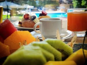 a table with a plate of fruit and a cup of coffee at Silva Hotel Splendid in Fiuggi