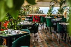 ein Restaurant mit Tischen, Stühlen und Pflanzen in der Unterkunft Hotel Villa Carlotta in Taormina