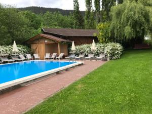 einen Pool mit Liegestühlen und Sonnenschirmen in der Unterkunft Residence Hauserhof in Rodeneck