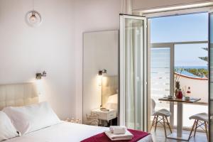 a bedroom with a bed and a table and a balcony at Pantanello Rooms Avola in Avola
