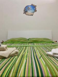uma cama com um edredão verde e amarelo em A Casa di Luca em Gallipoli