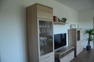 a large wooden cabinet with wine glasses in it at Obsthof Flammersberger in Volkach