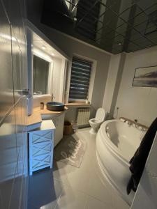 a bathroom with a tub and a toilet and a sink at Zarzecze 27A in Augustów +76 photos