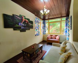 een woonkamer met een bank en een tafel bij Singtom Tea Resort in Darjeeling