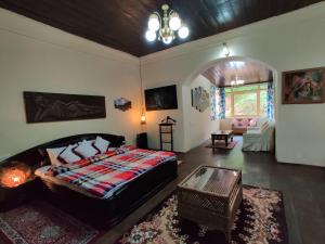 1 dormitorio con 1 cama y sala de estar en Singtom Tea Resort en Darjeeling