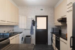 uma cozinha com uma porta preta e uma máquina de lavar roupa em The Bay 2 em Ballito