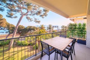d'une terrasse avec une table et des chaises en bois sur un balcon. dans l'établissement "Sea La Vie" - Croisette - 30 m plage - Palais - Congrès - Parking Privé - Clim, à Cannes