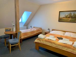 um quarto com duas camas, uma mesa e uma cadeira em Wellness hotel Rezidence em Nové Hrady