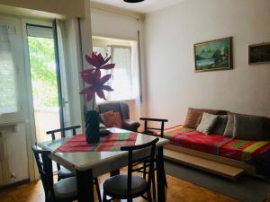 ein Wohnzimmer mit einem Tisch und einem Sofa in der Unterkunft Affittacamere Ferranti tra Caserma e stazione in Foligno