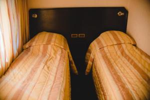 due letti uno accanto all'altro in una camera da letto di Family Hotel Shipkovo a Shipkovo