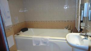 un bagno con una vasca bianca e un lavandino di Family Hotel Shipkovo a Shipkovo