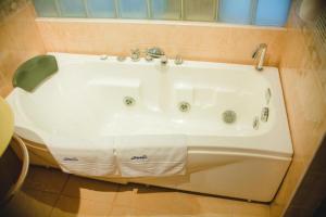 e bagno con vasca e lavandino. di Family Hotel Shipkovo a Shipkovo