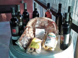 una cesta de comida y botellas de vino en una mesa en Tenuta Annibale, en Leverano