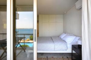 a bedroom with a bed and a view of the ocean at Kavouri Flat in Athens +25 photos