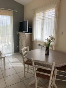 a dining room with a table and chairs and a tv at Gîte en Pays Cathare in Pomas