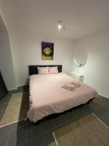 a bedroom with a large bed with pink sheets at Studio Just For 2 in Ostend