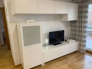 un centro di intrattenimento bianco con TV a schermo piatto di Apartamento Club Nautico By Solymar Holiday a Torre del Mar