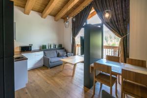 a kitchen and living room with a table and a couch at ChaletSKI Jasná, SKI-IN & SKI-OUT in Demanovska Dolina