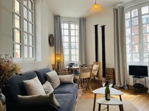 uma sala de estar com um sofá azul e uma mesa em L emeraude - Trouville em Trouville-sur-Mer