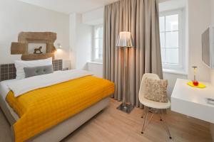 a bedroom with a yellow bed and a desk at Hotel Rössli in Zurich