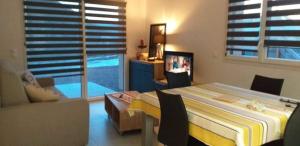 ein Schlafzimmer mit einem Bett, einer Couch und einem Fernseher in der Unterkunft Les balcons la haie des grisselles in Gérardmer