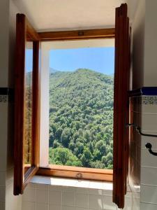 a window in a bathroom with a view of a mountain at Dream house, 80M2, Fresco painting on the vault in Marciana